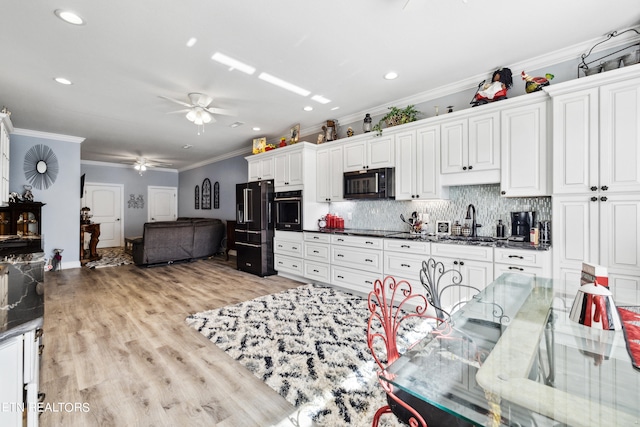 kitchen featuring ceiling fan, white cabinetry, light wood-type flooring, ornamental molding, and black appliances