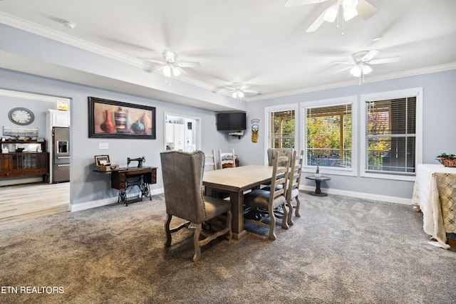 carpeted dining room with crown molding and ceiling fan