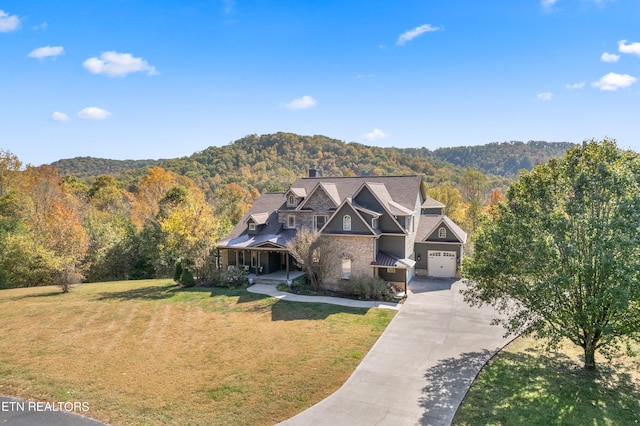 view of front of property with a mountain view, a front yard, and a garage