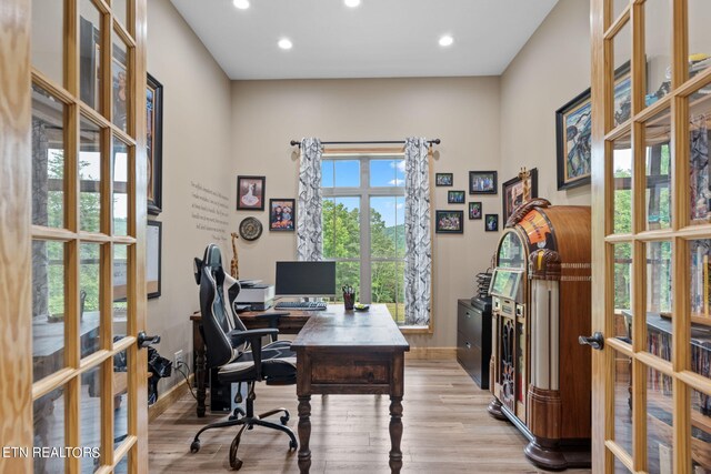 office space with french doors, light wood-type flooring, and plenty of natural light