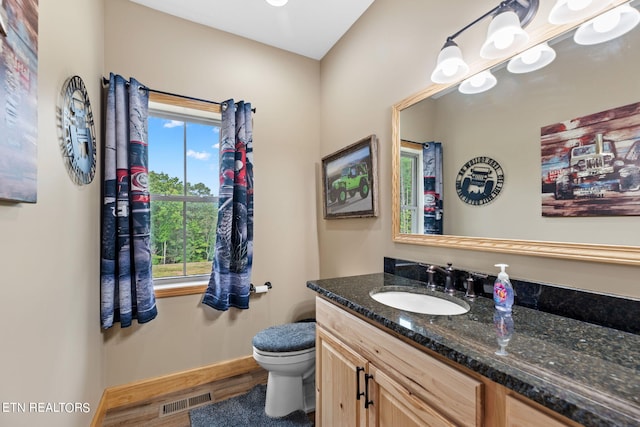 bathroom with hardwood / wood-style floors, vanity, and toilet