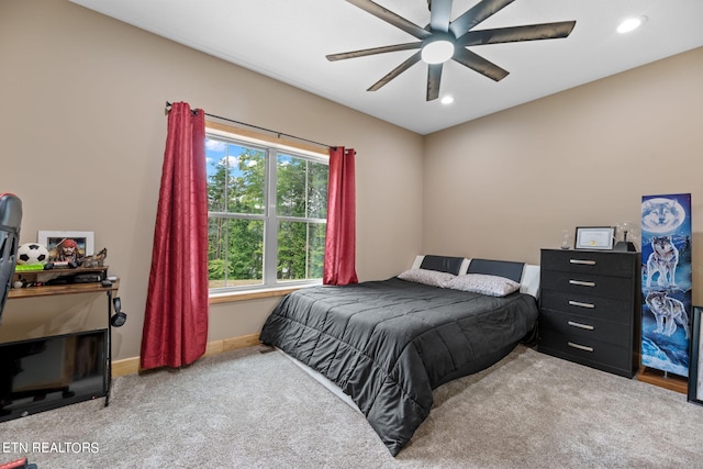 carpeted bedroom featuring ceiling fan and multiple windows