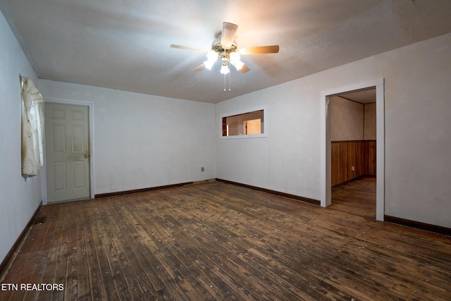 empty room featuring a textured ceiling, ceiling fan, and dark wood-type flooring