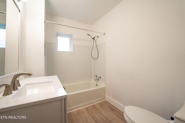 full bathroom with vanity, vaulted ceiling, wood-type flooring, washtub / shower combination, and toilet