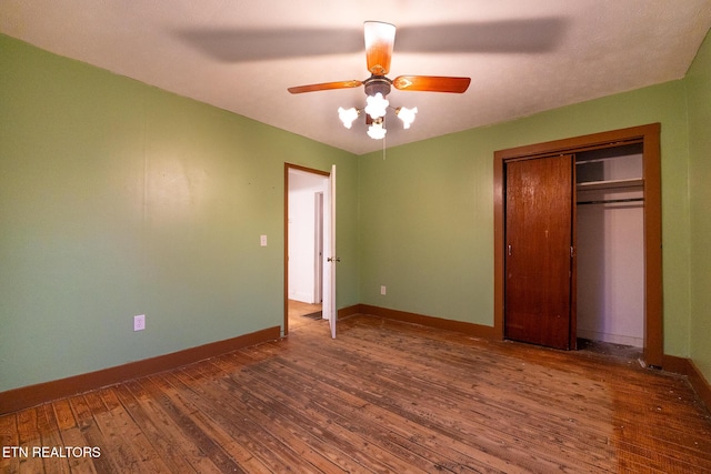 unfurnished bedroom with ceiling fan, dark wood-type flooring, and a closet