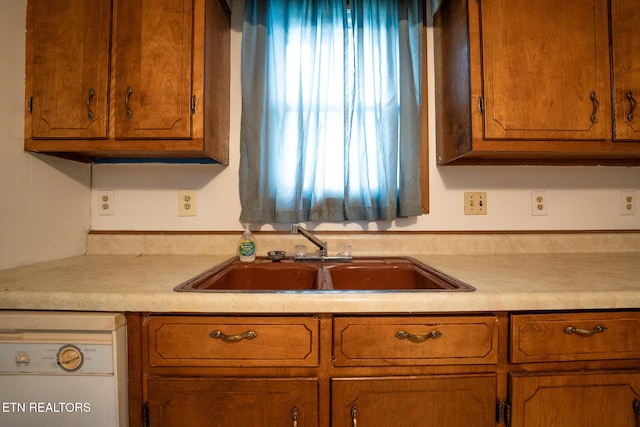 kitchen featuring white dishwasher and sink