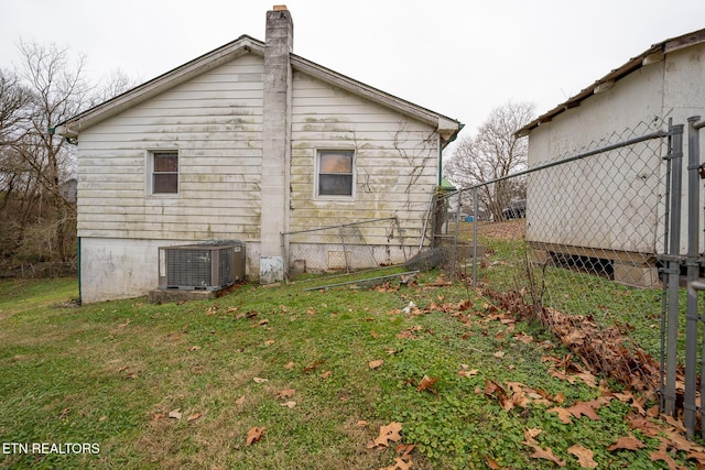 view of home's exterior with a yard and central AC