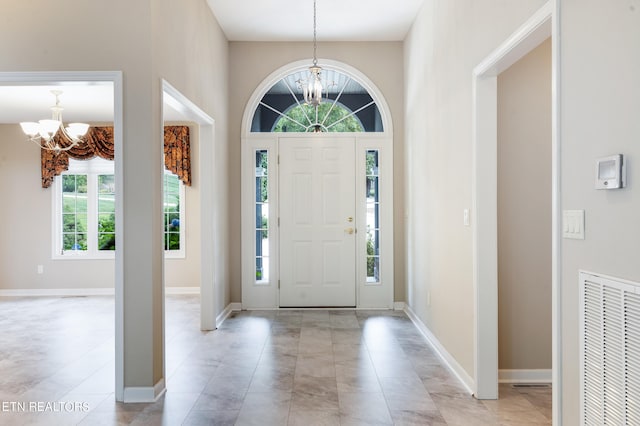 foyer featuring an inviting chandelier and light tile patterned floors