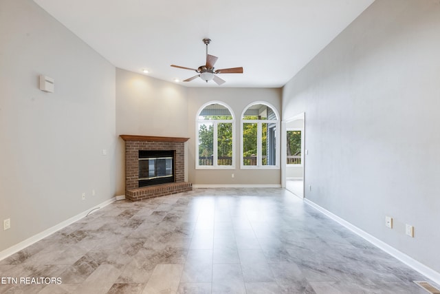 unfurnished living room with ceiling fan and a fireplace