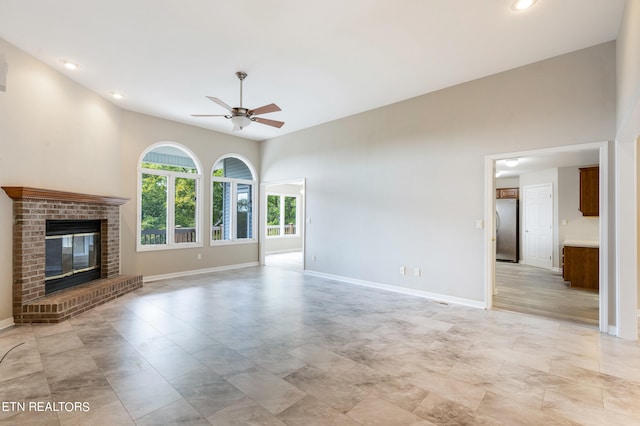 unfurnished living room featuring ceiling fan and a fireplace