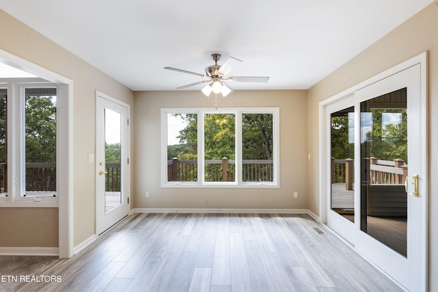 unfurnished sunroom with ceiling fan