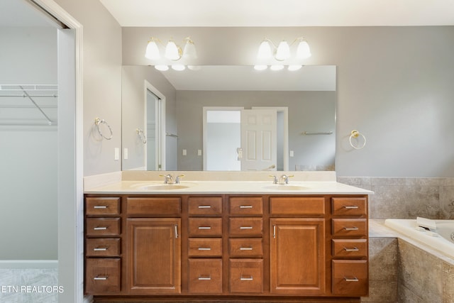 bathroom featuring tiled bath and vanity