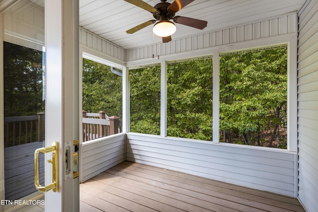 unfurnished sunroom featuring wooden ceiling, ceiling fan, and plenty of natural light