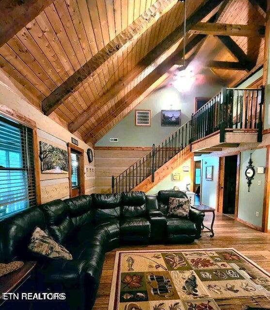 living room featuring wood ceiling, beam ceiling, high vaulted ceiling, and hardwood / wood-style flooring