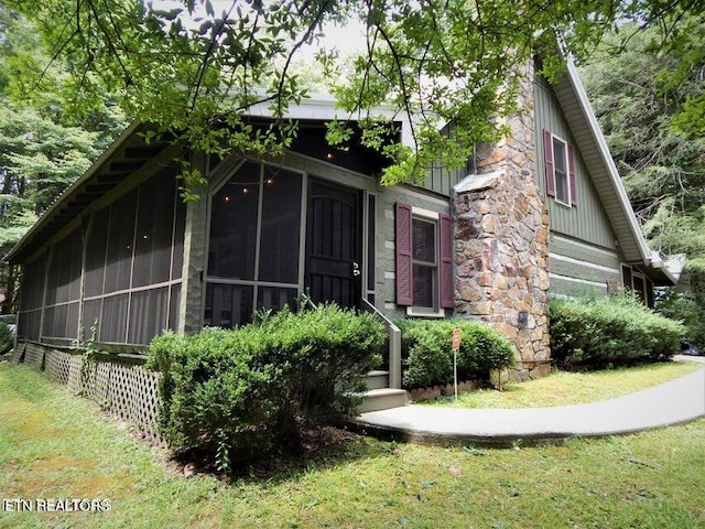 view of front facade with a sunroom and a front yard