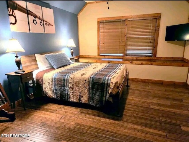 bedroom featuring lofted ceiling and hardwood / wood-style flooring