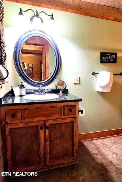 bathroom featuring beamed ceiling and vanity