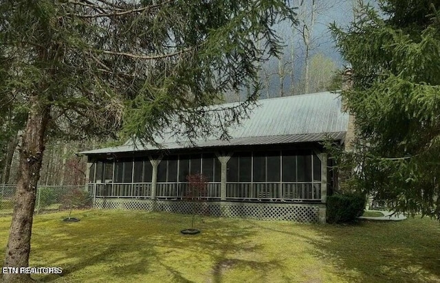 exterior space featuring a lawn and a sunroom