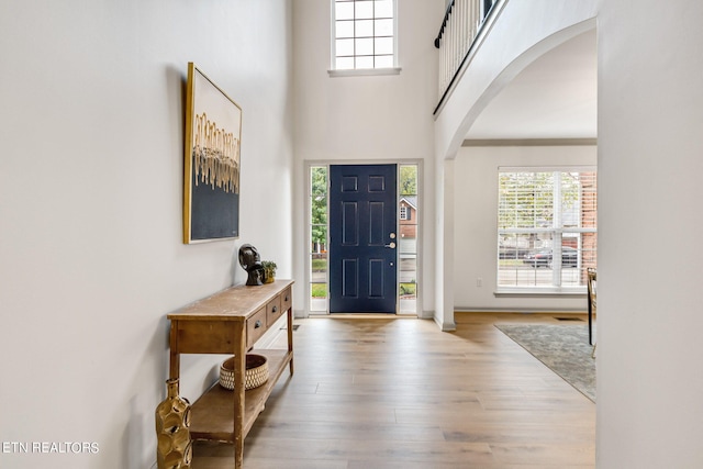 entryway with light hardwood / wood-style flooring and a high ceiling