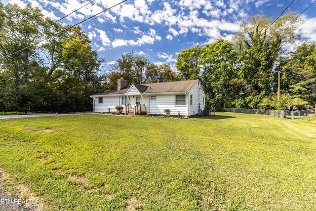 ranch-style home featuring central AC unit and a front yard