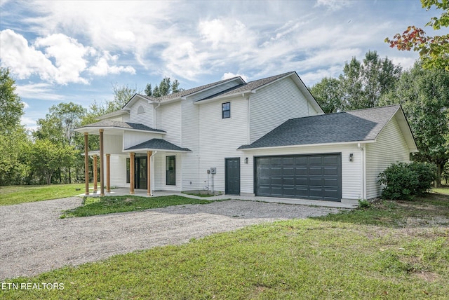 view of front of property with a front yard, a garage, and covered porch