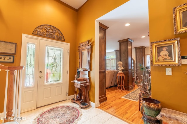 foyer with ornamental molding and light hardwood / wood-style floors