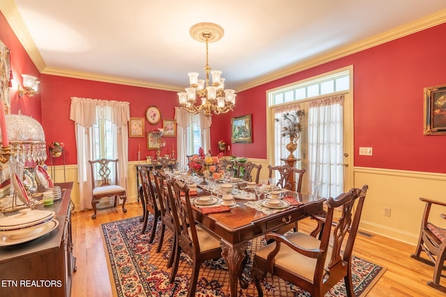 dining room with crown molding, a chandelier, and light wood-type flooring