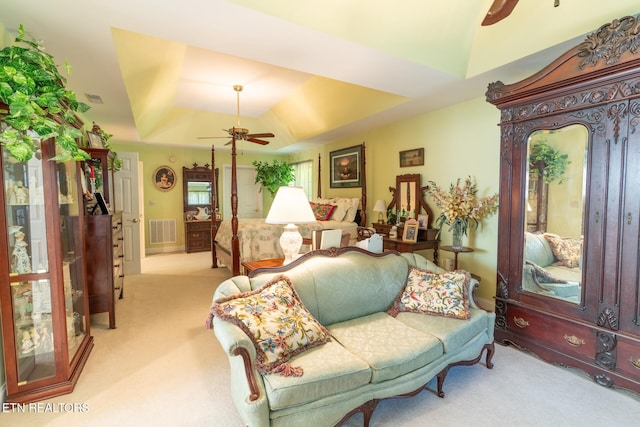 bedroom with a tray ceiling and light colored carpet