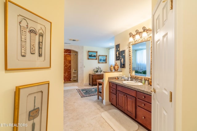 bathroom featuring tile patterned flooring, walk in shower, and vanity