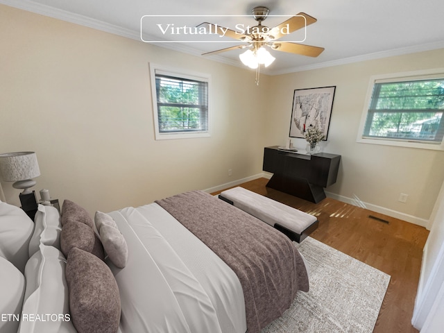 bedroom with ceiling fan, hardwood / wood-style flooring, and crown molding