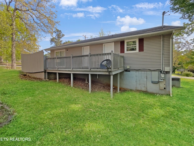 rear view of house featuring a yard and a deck