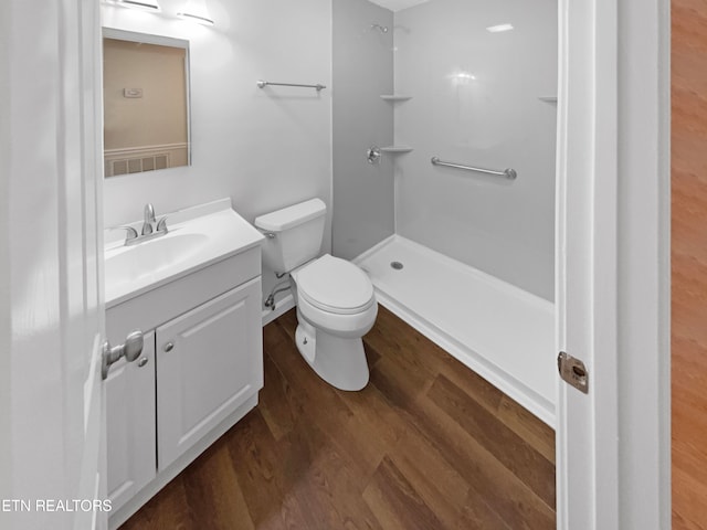 bathroom with a shower, toilet, vanity, and hardwood / wood-style flooring