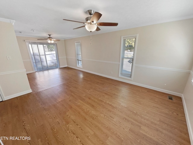 empty room with plenty of natural light, ceiling fan, and light wood-type flooring