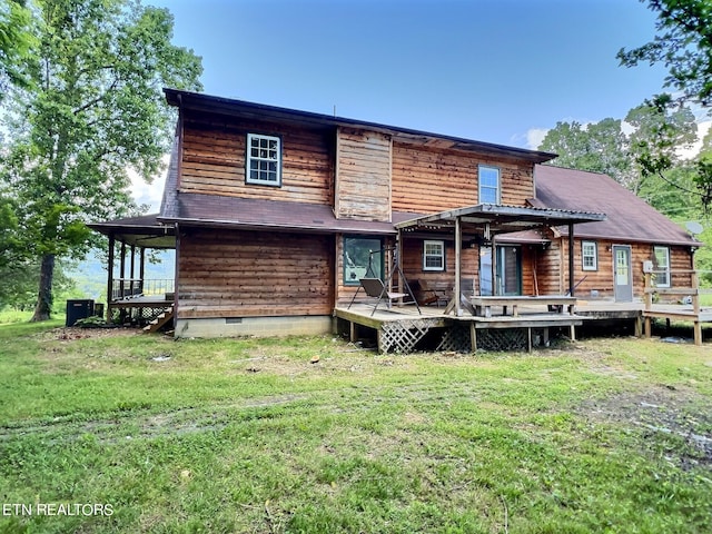 back of property featuring a lawn and a wooden deck