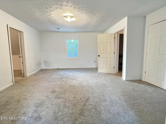 unfurnished bedroom with a textured ceiling and carpet floors