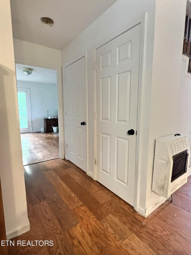 corridor featuring hardwood / wood-style flooring and heating unit