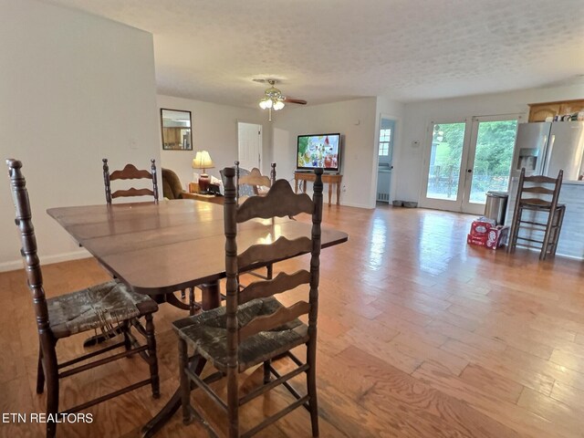 dining area featuring a textured ceiling, ceiling fan, and light wood-type flooring