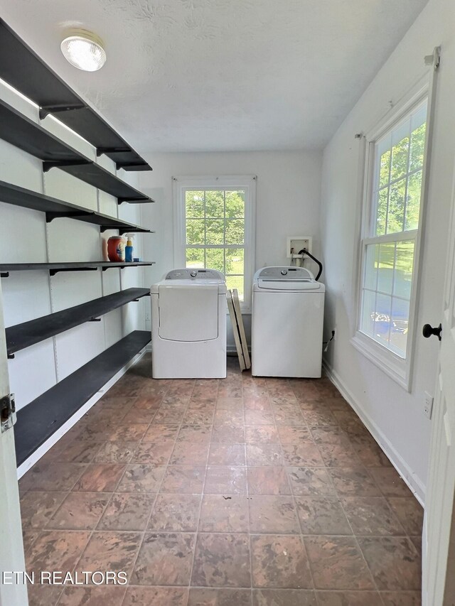 laundry area with a textured ceiling and washing machine and clothes dryer