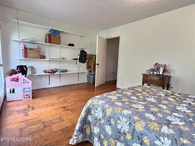 bedroom featuring wood-type flooring and a textured ceiling