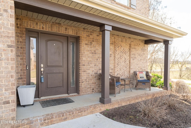 view of exterior entry featuring brick siding