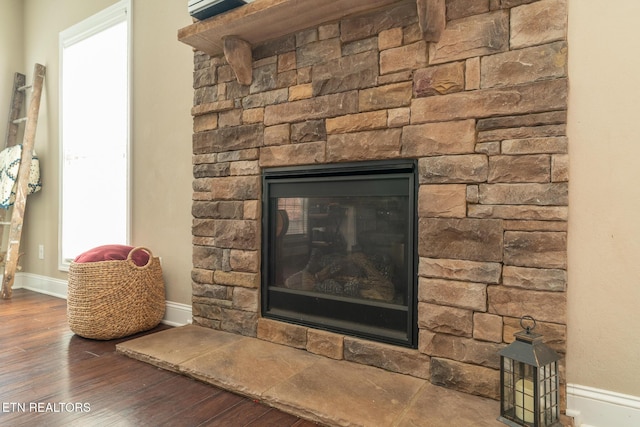 room details featuring a fireplace, wood finished floors, and baseboards