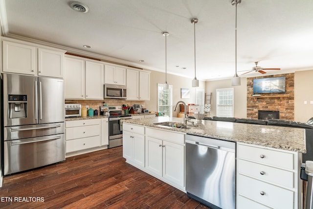 kitchen with ornamental molding, appliances with stainless steel finishes, a sink, and visible vents