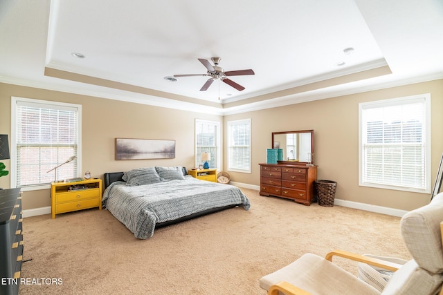 carpeted bedroom featuring ornamental molding, a raised ceiling, a ceiling fan, and baseboards