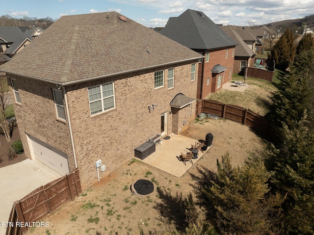 view of property exterior featuring a patio area, a fenced backyard, a fire pit, and brick siding