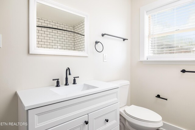 bathroom featuring vanity, toilet, and tiled shower