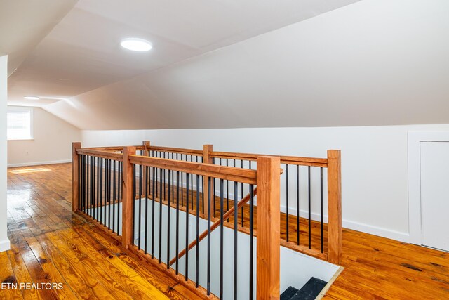 hallway with wood-type flooring and lofted ceiling