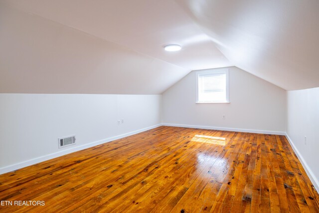 additional living space featuring wood-type flooring and lofted ceiling