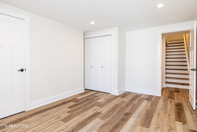 unfurnished bedroom featuring light wood-type flooring and a closet