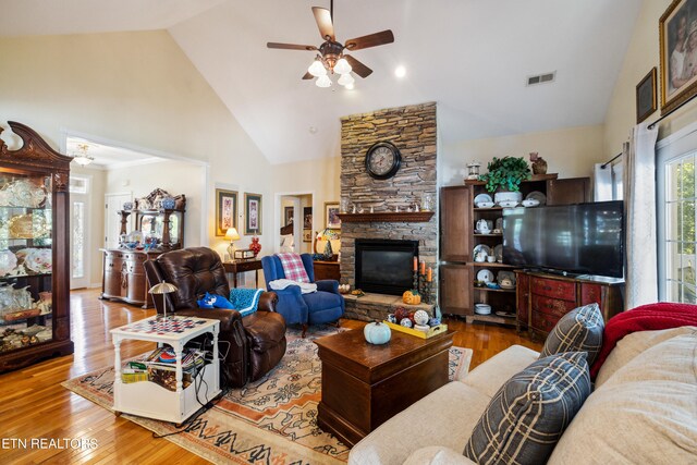 living room with high vaulted ceiling, a fireplace, ceiling fan, and hardwood / wood-style flooring