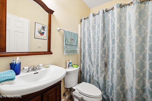 bathroom featuring a shower with shower curtain, vanity, and toilet